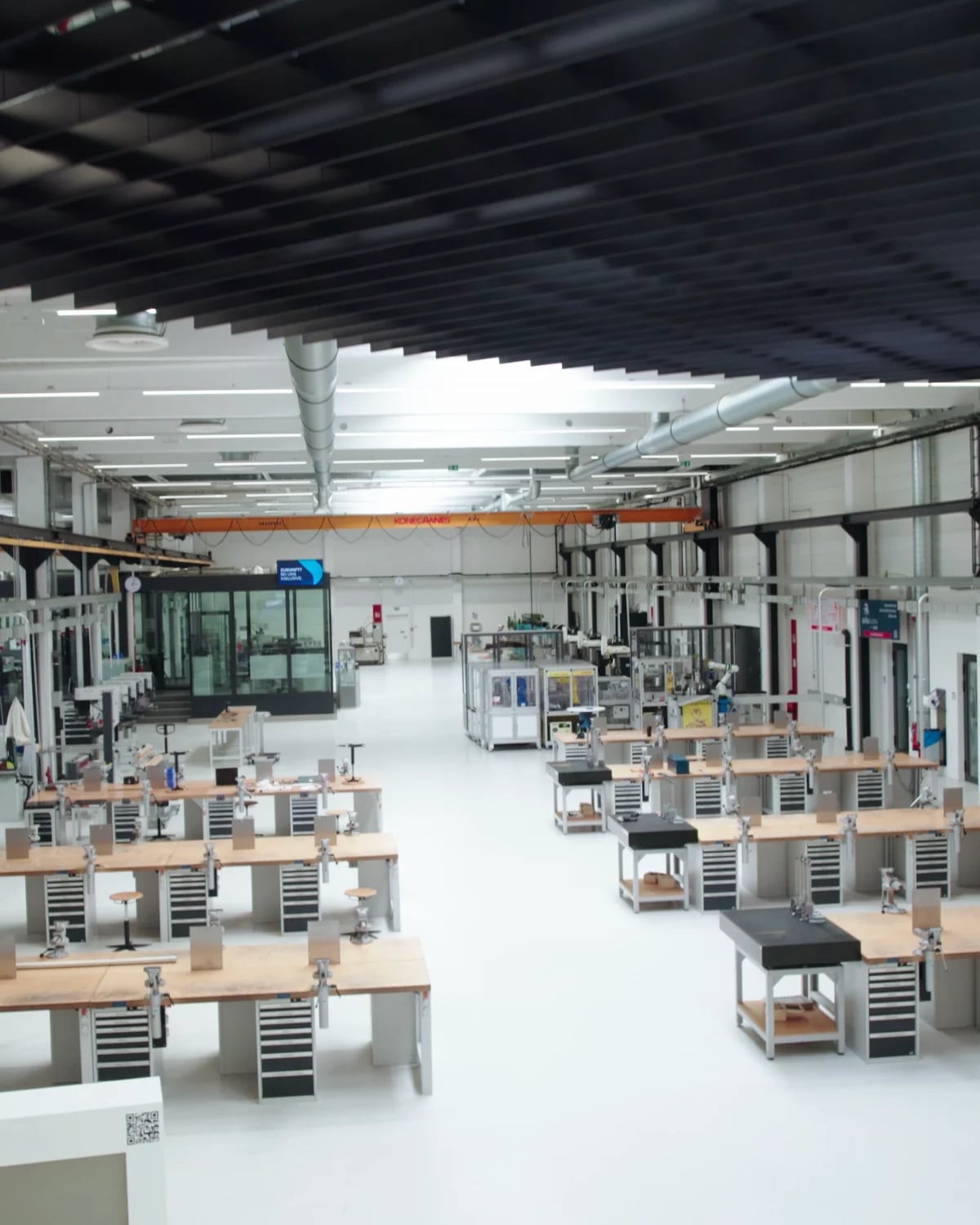 Blick von oben in die helle Werkshalle des sterner training center mit Reihen von Werkbänken samt Schraubstöcken und Maschinen im Hintergrund; vorne ein Schriftzug mit „sterner – be part of it.“