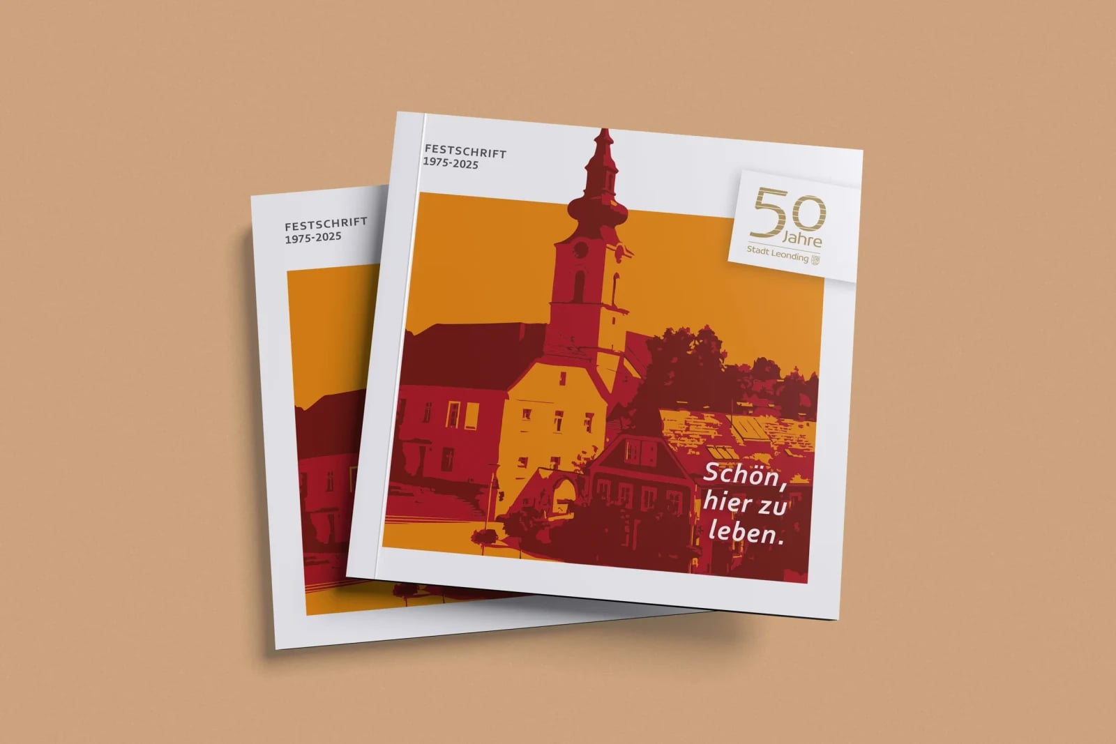 Festschrift „50 Jahre Stadt Leonding" 1975–2025 – quadratische Broschüre mit illustriertem Kirchturm in Rot-Orange und Slogan „Schön, hier zu leben."