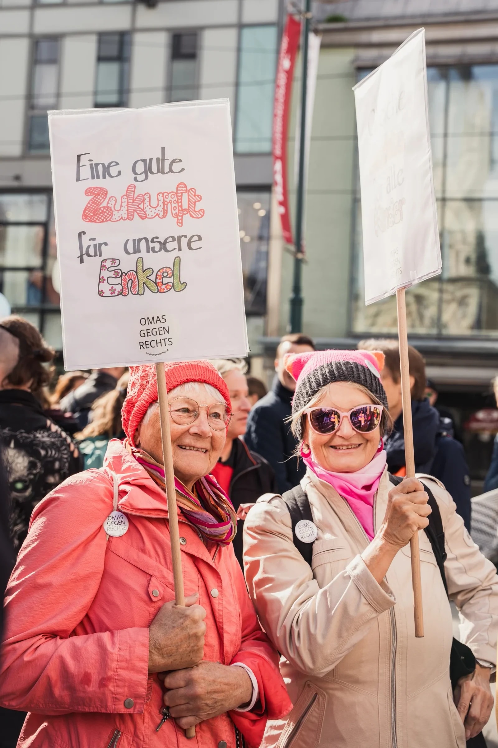 Zwei ältere Frauen von „Omas gegen Rechts" mit Schild „Eine gute Zukunft für unsere Enkel" bei der Kinderrechte-Demo.