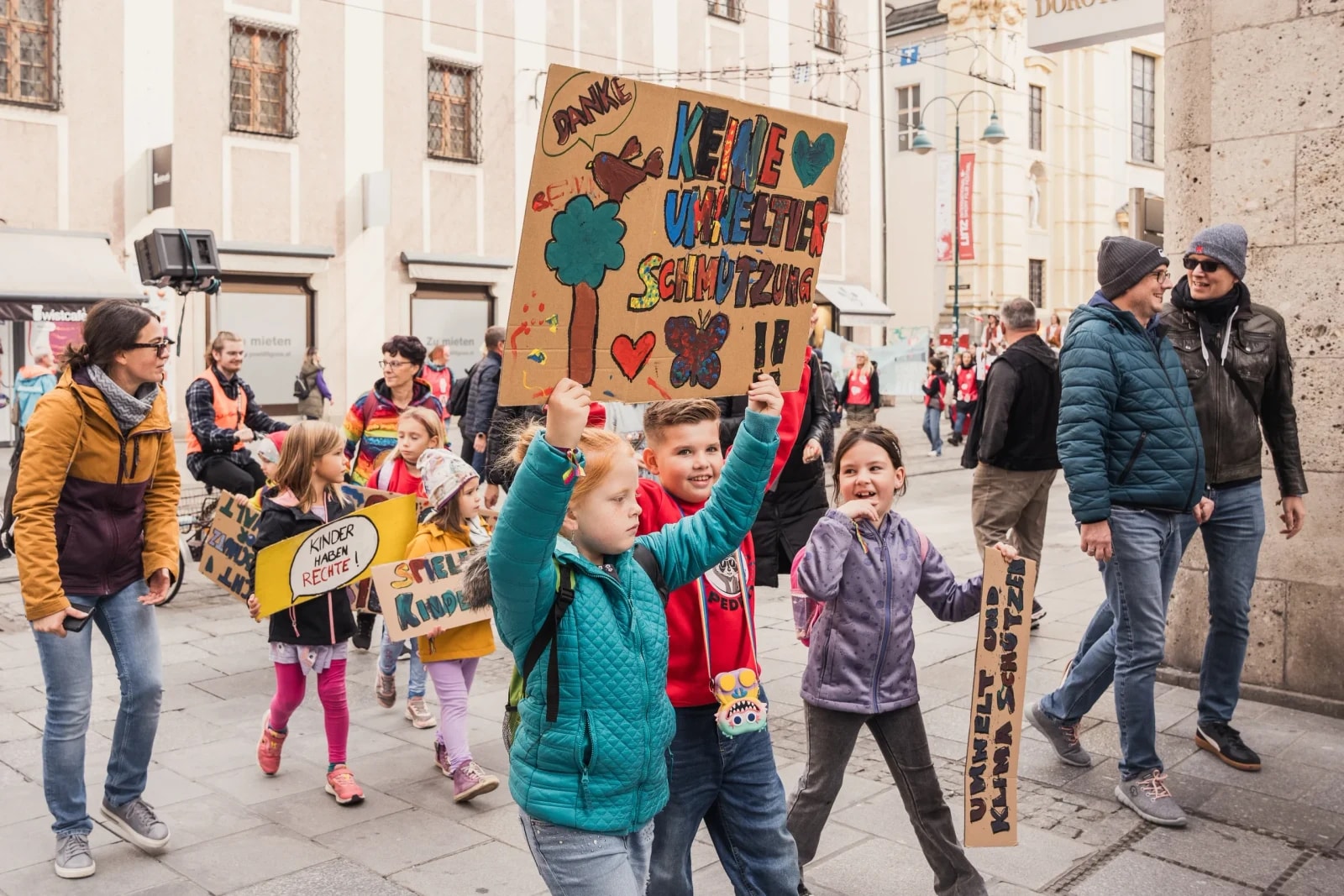 Kinder ziehen mit selbst gemalten Schildern gegen Umweltverschmutzung durch die Innenstadt.