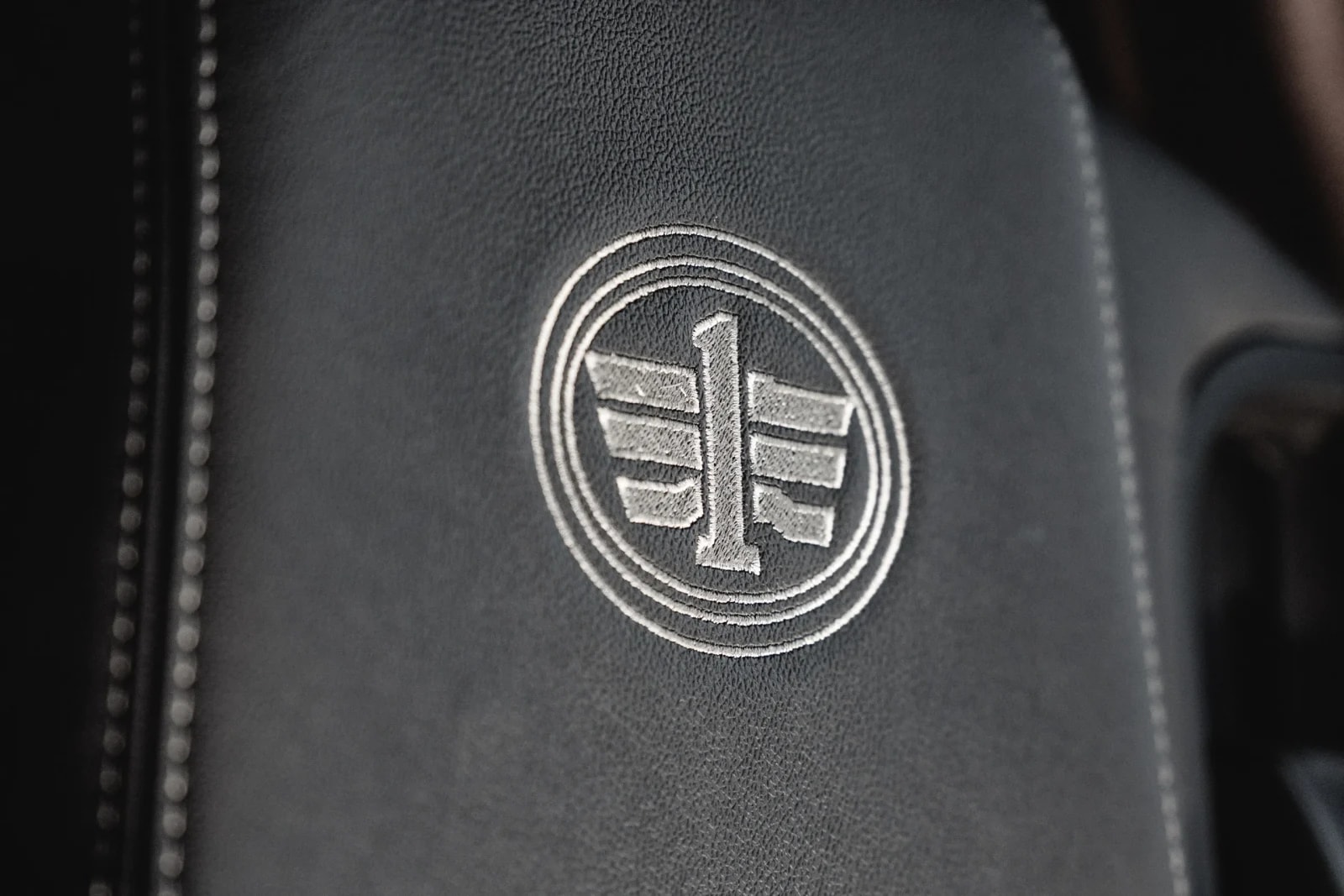 Detailaufnahme des gestickten FAW Logos auf dem Ledersitz im Fahrerhaus.