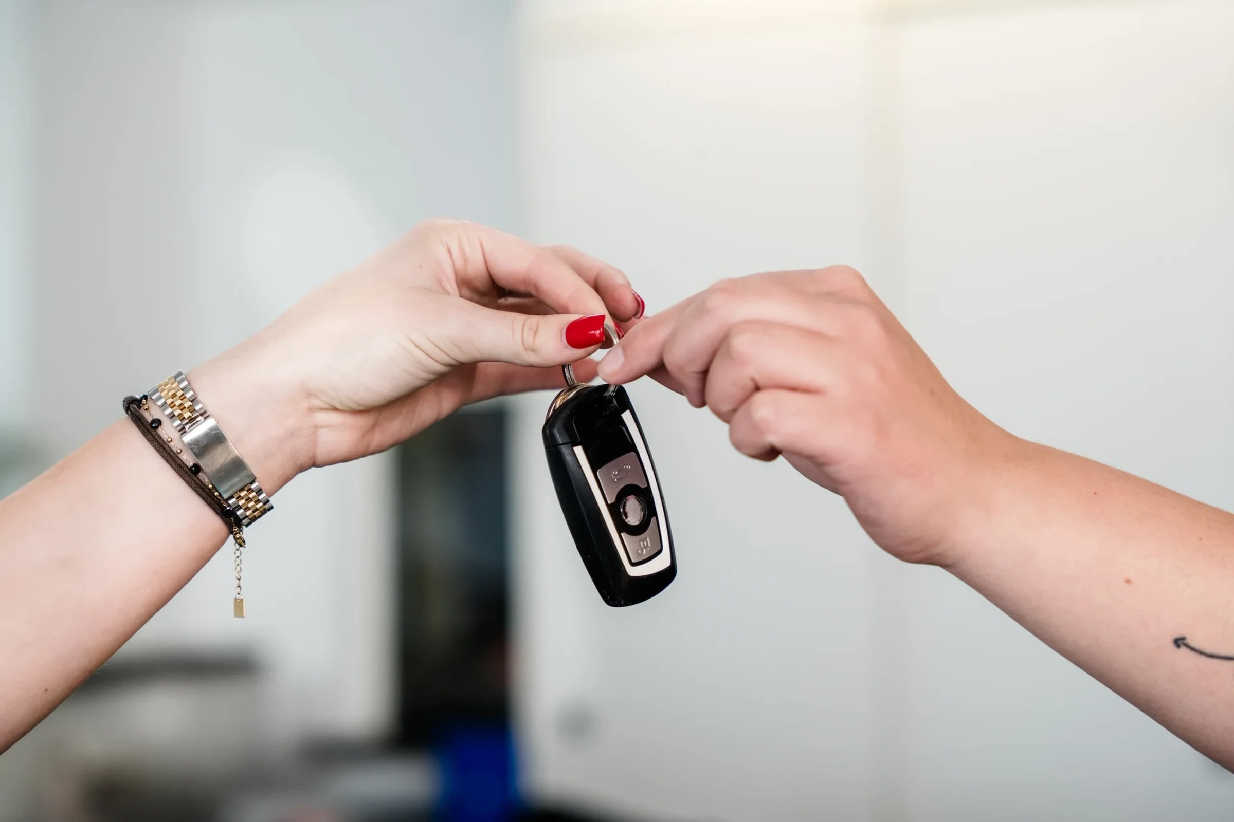 Schlüsselübergabe: Mitarbeiterin reicht einer Kundin den Autoschlüssel nach der Reparatur.